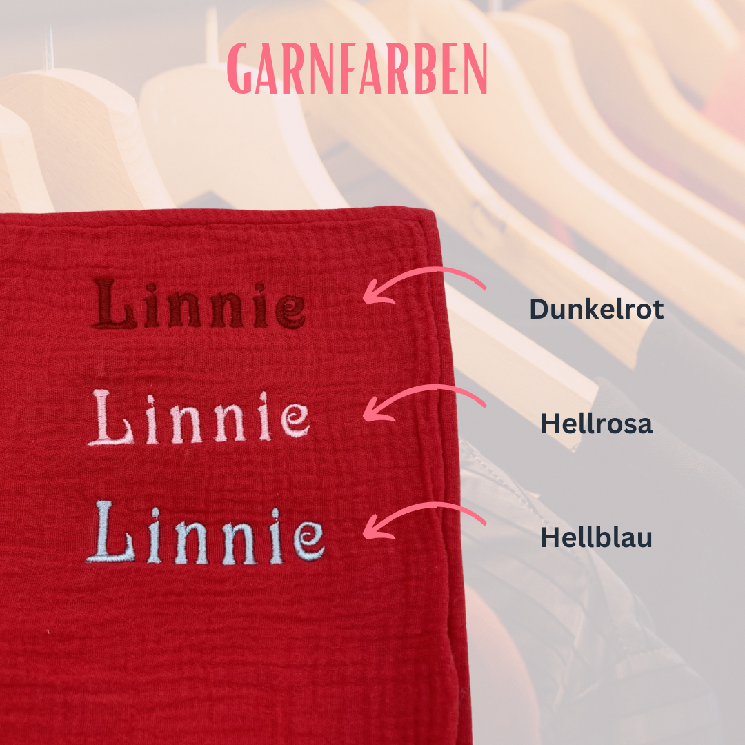 Bild zeigt die beispielhafte Bestickung des Geburtstuchs mit einem Namen und die drei verfügbaren Garnfarben (hellrosa, dunkelrot, hellblau)