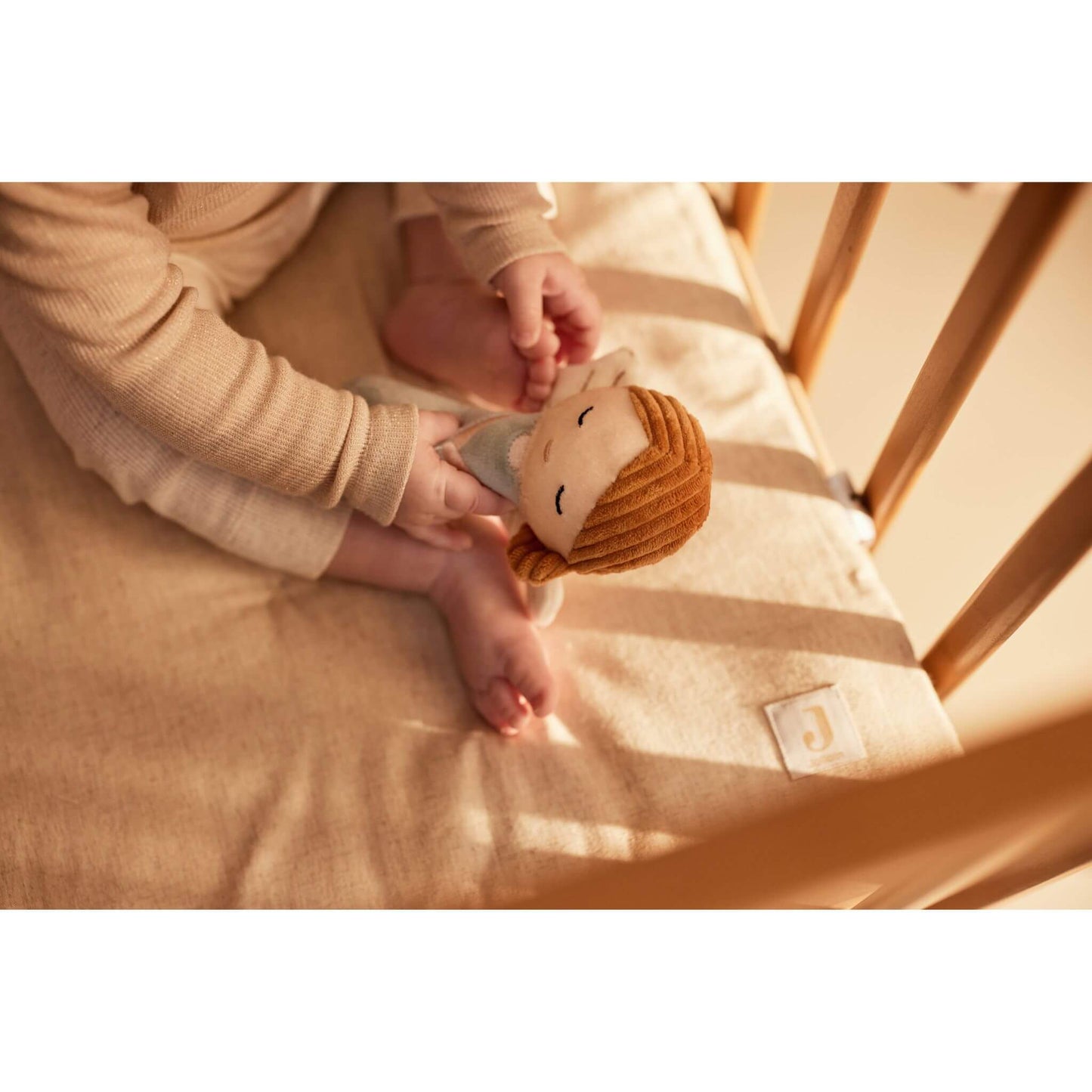 Baby greift nach Babyrassel Schutzengel / Fee