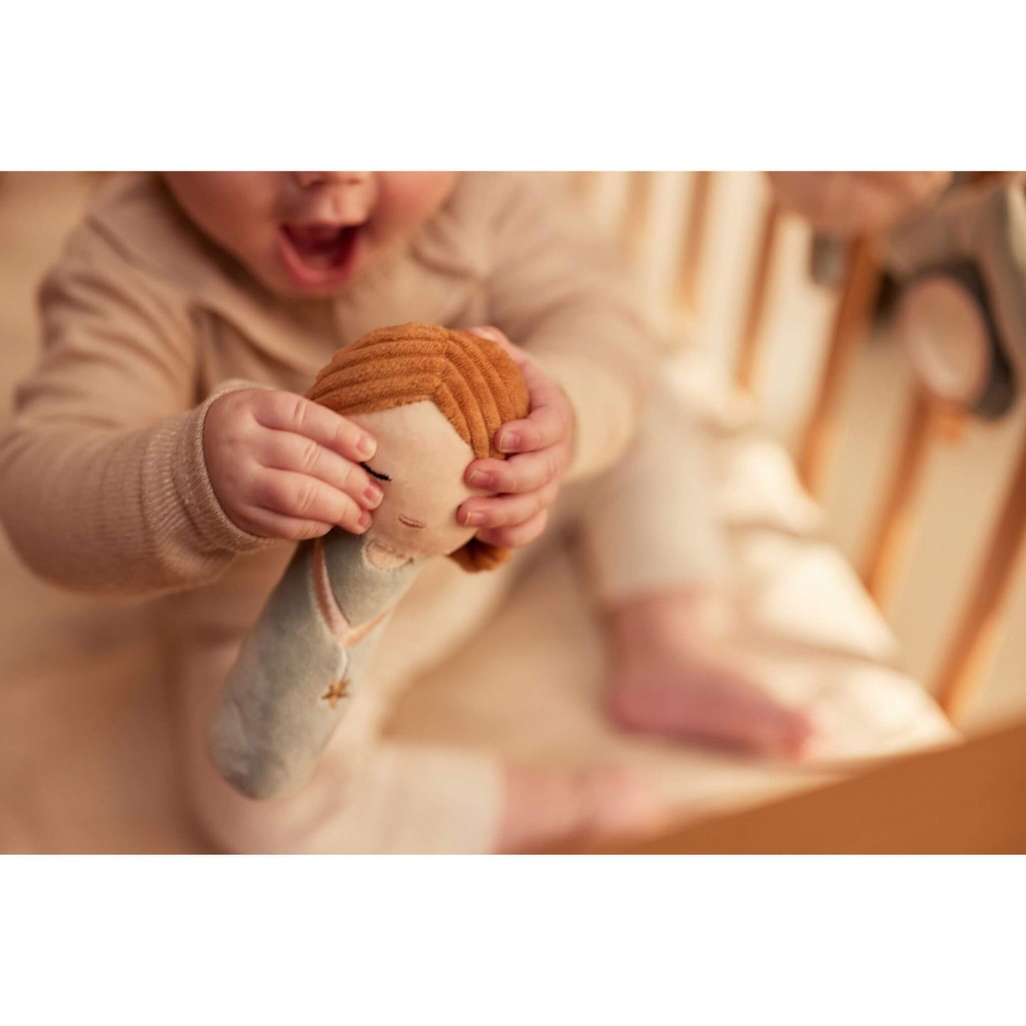 Baby schüttelt Rassel Schutzengel / Fee und lacht weil Geräusch erklingt