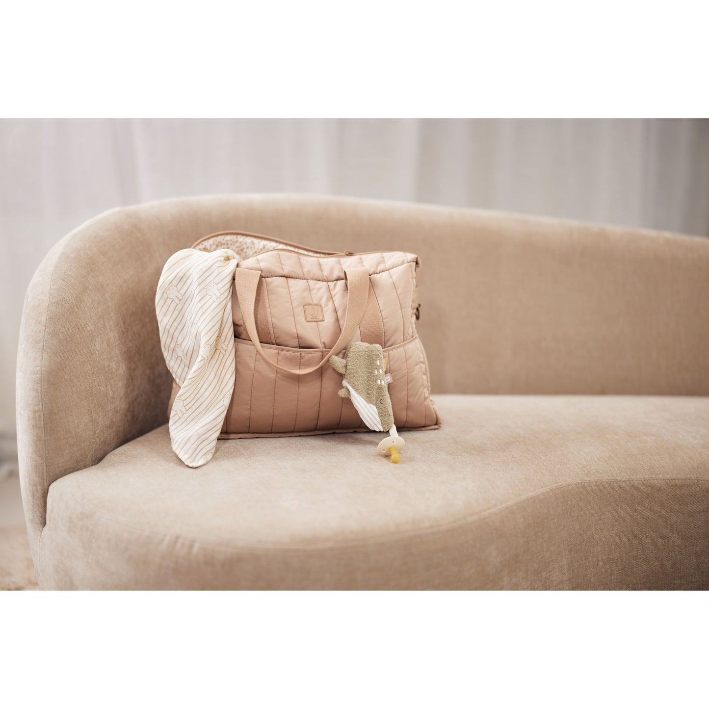 Wickeltasche in Farbe Biscuit Beige steht auf Couch