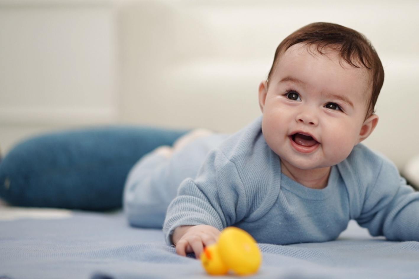 Banner mit Baby im blauen Merinowolle Strampler