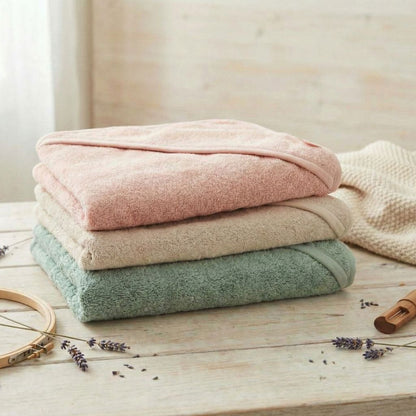 Baby Kapuzenhandtücher in rosa, beige und grün liegen gestapelt aufeinander ohne Personalisierung