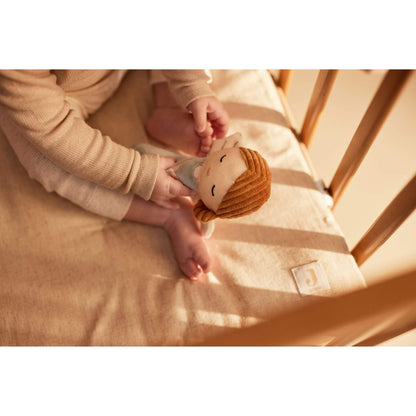 Baby greift nach Babyrassel Schutzengel / Fee