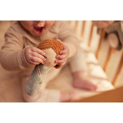 Baby schüttelt Rassel Schutzengel / Fee und lacht weil Geräusch erklingt
