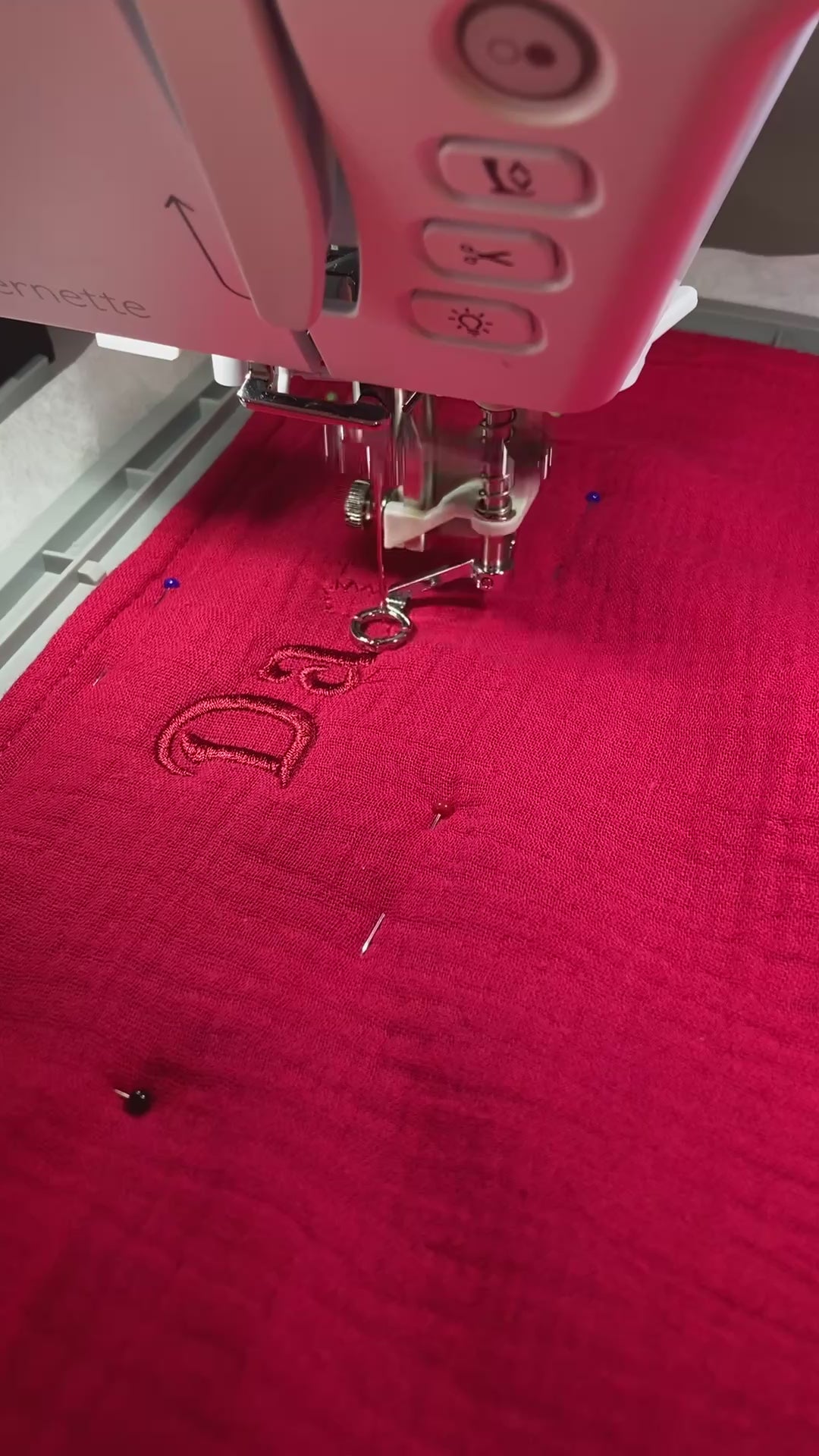 Rotes Geburtstuch wird mit Namen von der Stickmaschine bestickt