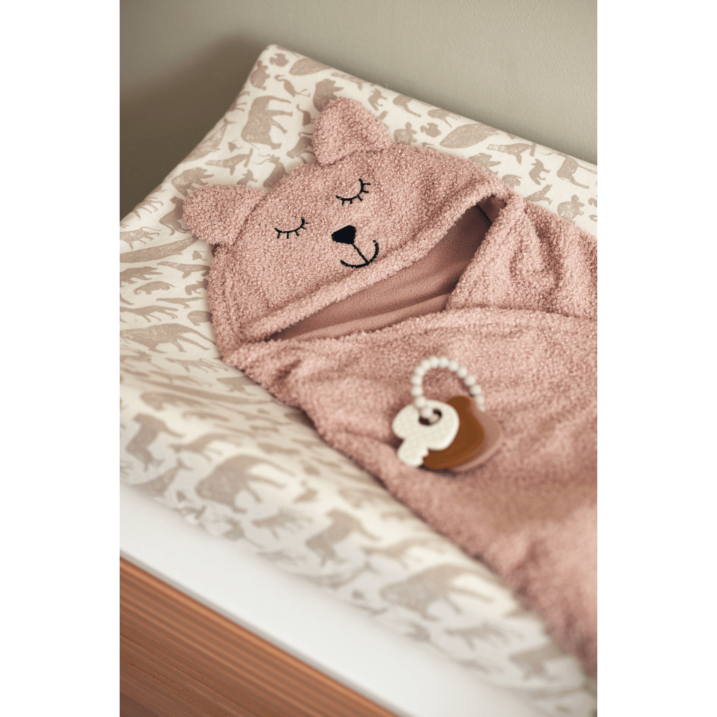 Puckdecke Bär in Rosa liegt auf Wickeltisch