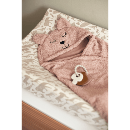Puckdecke Bär in Rosa liegt auf Wickeltisch