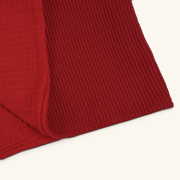 Das rote Geburtstuch aufgeschlagen sodass beide Seiten des Materials gut sichtbar sind.