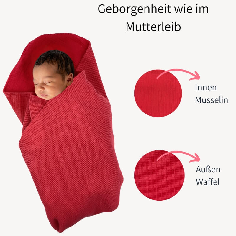 Baby im roten Geburtstuch eingewickelt mit Slogan: Das Tuch schenkt Geborgenheit wie im Mutterleib. Materialzusammensetzung Musselin und Waffel wird gezeigt.