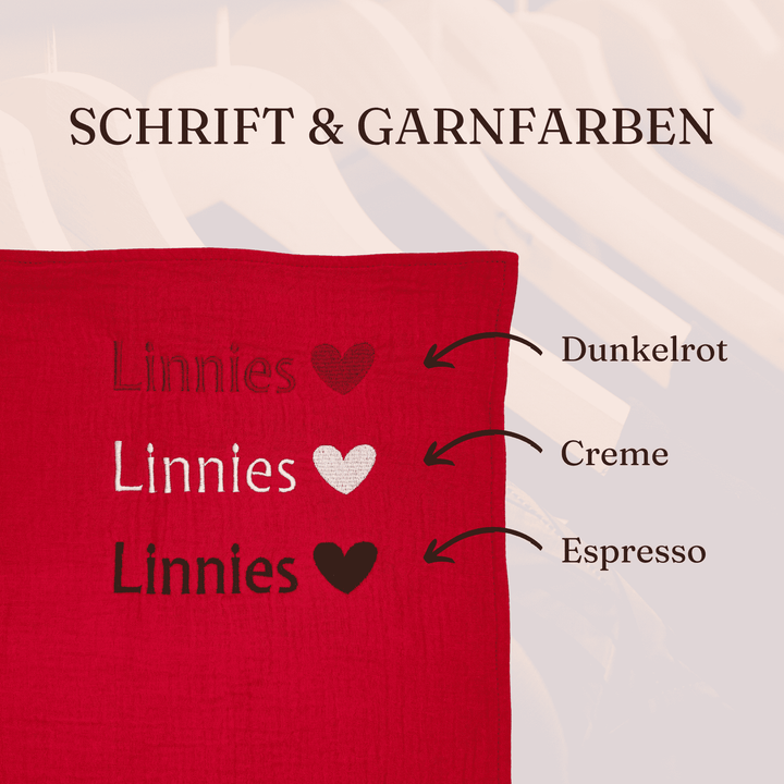 Bild zeigt die beispielhafte Bestickung des Geburtstuchs mit einem Namen und die drei verfügbaren Garnfarben (Dunkelrot, Creme Weiß / Espresso Braun)