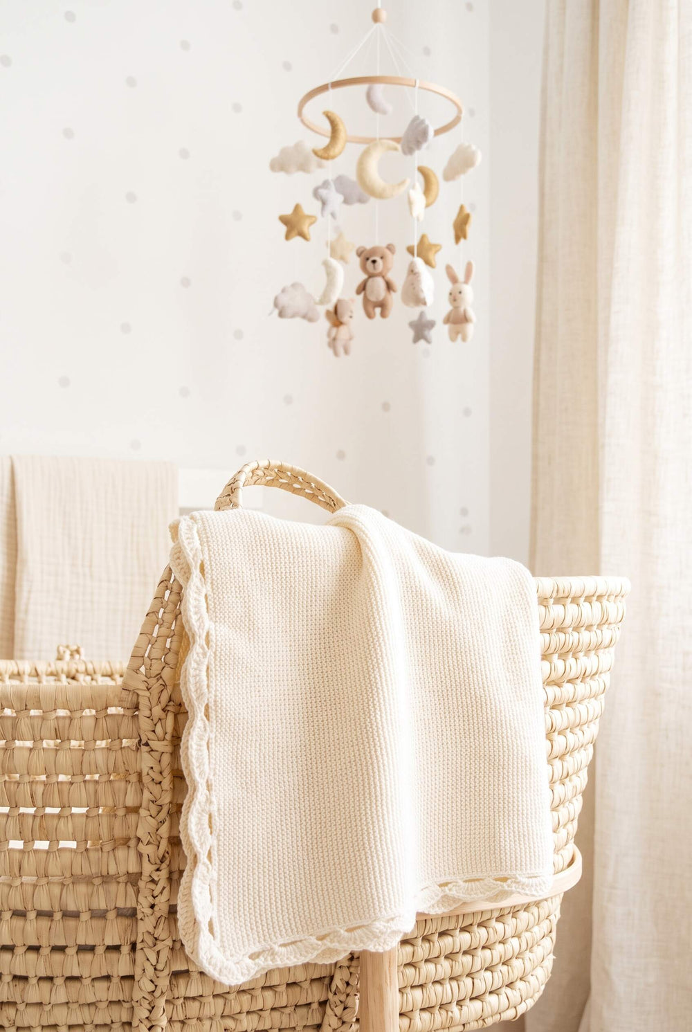 Cremefarbene Strickdecke von Linnie's über einem Stubenkorb im hellen Kinderzimmer