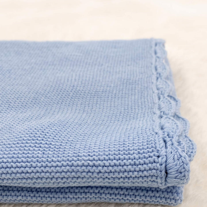 Detailaufnahme des gehäkelten Muschelrands der hellblauen Strickdecke von Linnie&