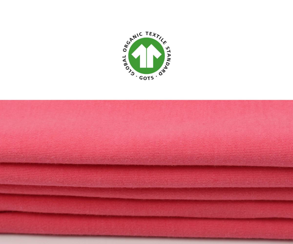 Nahaufnahme des Materials Bio-Baumwolle des Geburtskleides mit GOTS-Siegel