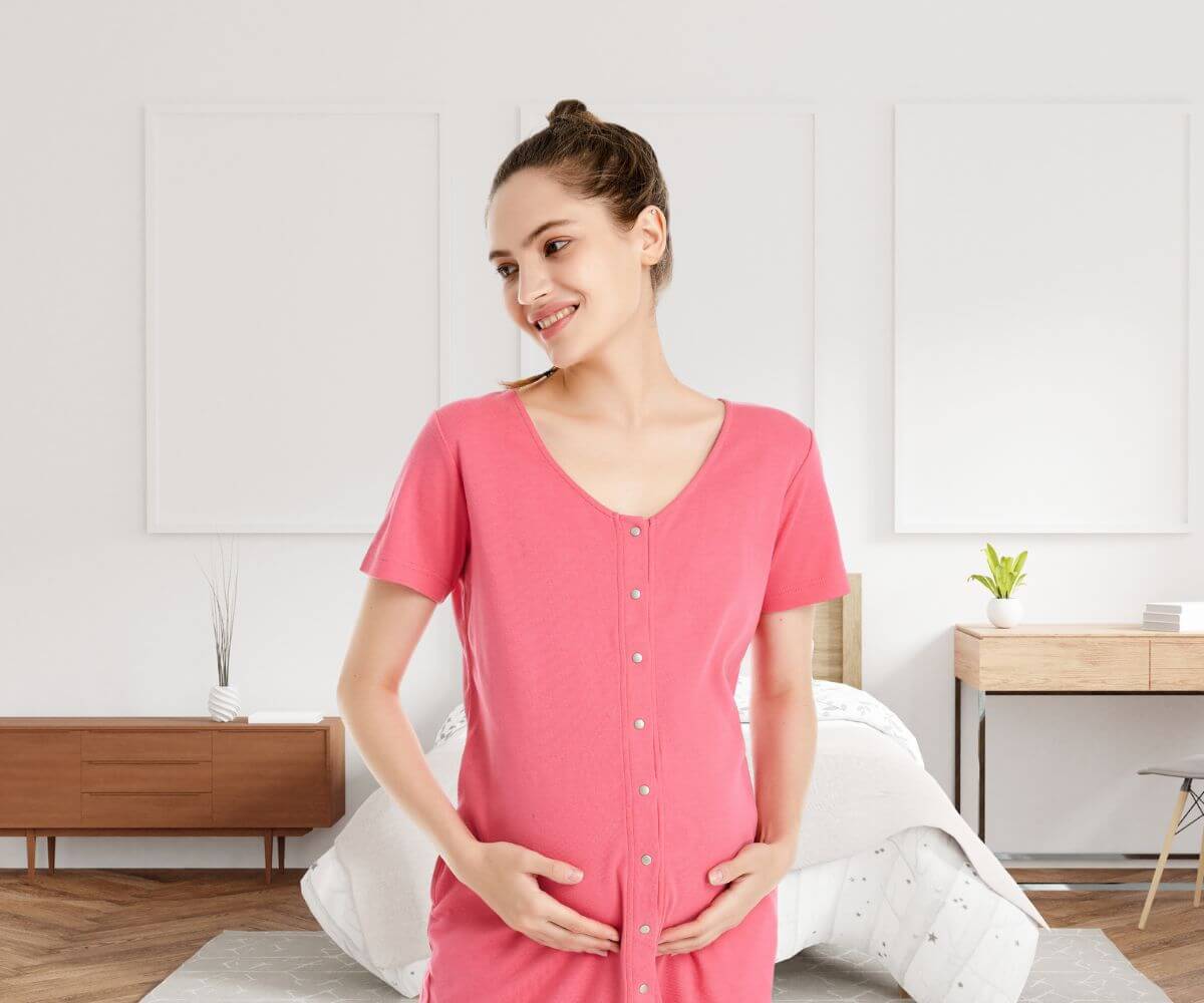 Schwangere mit Geburtskleid zeigt Knopfleiste vorne für Stillfunktion und Bonding (Skin-to-Skin-Funktion)